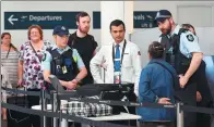  ?? AFP ?? Police help screen passengers at Sydney Airport on Sunday. Australia has foiled an Islamist-inspired "terrorist plot" to bring down an airplane with an improvised explosive, authoritie­s said, after four people were arrested in raids across Sydney.