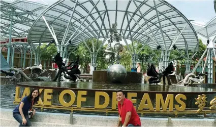  ??  ?? RESORTS WORLD. Victor and Jill Carvajal of Travelways pose by the romantic Lake of Dreams in RW.