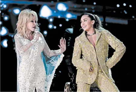  ?? ROBYN BECK/GETTY-AFP ?? Dolly Parton, left, and Miley Cyrus perform during the Grammy Awards in Los Angeles on Sunday.