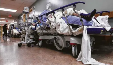  ?? Mario Tama / Getty Images ?? Patients lie on stretchers in a hallway Tuesday in the overloaded Providence St. Mary Medical Center in Apple Valley amid a surge in COVID-19 cases traced to holiday gatherings. Hospitals hope to avoid rationing care to patients more likely to survive.