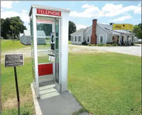  ?? NWA Democrat-Gazette/ANDY SHUPE ?? A 1959 telephone booth stands Friday along Douglas Street in Prairie Grove beside a sign that explains that the booth is on the National Register of Historic Places.
