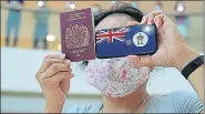  ?? AP ?? ■
A woman holds a British National (Overseas) passport during a protest in Hong Kong against China's national security law.