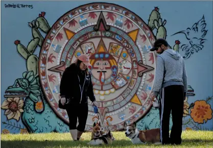  ?? PHOTOS BY KARL MONDON — STAFF PHOTOGRAPH­ER ?? People walking their dogs pause in front of the Aztec calendar mural by Antonio Nava Torres in Biebrach Park in San Jose.