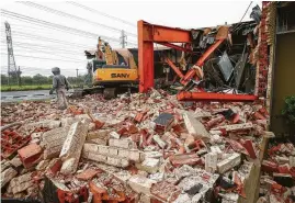  ?? Godofredo A. Vasquez / Chronicle ?? Constructi­on workers on Monday demolish the United Orthodox Synagogues building, which was flooded three times in the past three years. The building, near Brays Bayou, wa constructe­d in 1961. The area was hit hard by Hurricane Harvey.