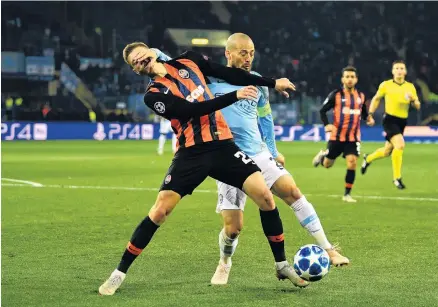  ?? PHOTO: GETTY IMAGES ?? Guess who? David Silva (right), one of three goal scorers for Manchester City, challenges for the ball with Mykola Matviyenko, of Shakhtar Donetsk, during the group F match of the Uefa Champions League at Metalist Stadium yesterday.