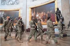  ?? SAUL LOEB/ AFP VIA GETTY IMAGES ?? National Guard troops walk through the Rotunda of the Capitol as the House considered impeaching President Donald Trump.