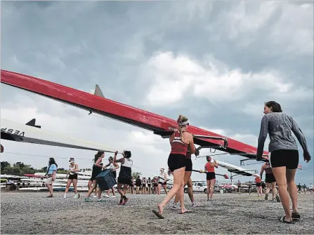  ?? BOB TYMCZYSZYN TORSTAR ?? Rowers take their boats off the water as the weather disrupts racing on the first day of heats at the Royal Canadian Henley Regatta.