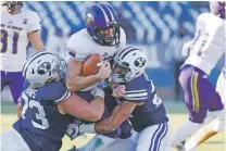  ?? JEFF SWINGER/ASSOCIATED PRESS FILE PHOTO ?? North Alabama quarterbac­k Rett Files, center, is tackled by BYU defensive lineman Caden Haws, left, and defensive back Tavita Gagnier on Nov. 21 in Provo, Utah.