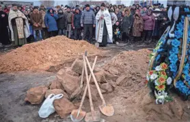  ?? EMILIO MORENATTI/AP ?? Friends and relatives mourn at the funeral Monday of Oleksandr Maksymenko in his home village of Kniazhychi, east of Kyiv. Oleksandr, a civilian who was a volunteer in the armed forces of Ukraine, was killed in combat.