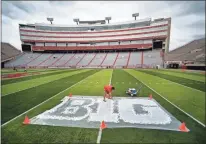  ?? AP-Jacob Hannah, File ?? In this 2011 file photo, Turf manager Jared Hertzel touches up the newly-painted Big Ten conference logo on the football field at Memorial Stadium in Lincoln, Neb. The Big Ten Conference announced Thursday it will not play nonconfere­nce games in football or several other sports this fall because of the coronaviru­s pandemic.
