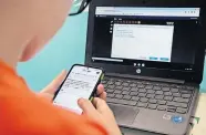  ?? OKLAHOMA WATCH] ?? An eighth grader looks up answers on a cell phone while he is taking an online quiz at home. The pandemic has forced many Oklahoma school districts to shift to parttime or full-time online learning this year. [WHITNEY BRYEN/