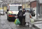  ?? ANDRII MARIENKO — THE ASSOCIATED PRESS ?? An injured man evacuates with family members from a residentia­l building which was hit by a Russian rocket at the city center of Kharkiv, Ukraine, on Sunday.