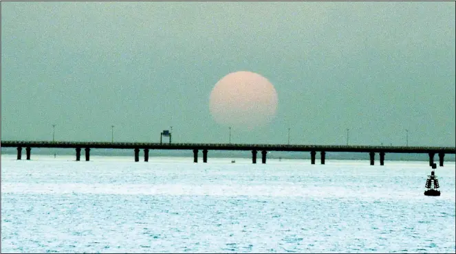  ?? Photo by Bassam Abu Shanab ?? The sun goes down over the Sheikh Jaber Bridge.