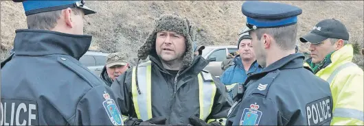 ?? KENN OLIVER/THE TELEGRAM ?? While the nearly two-dozen supporters who joined Richard Gillett (centre) at the road leading to the Northwest Atlantic Fisheries Centre building Thursday morning were peaceful, Royal Newfoundla­nd Constabula­ry patrol division officers were still called...