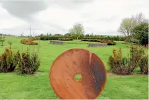  ??  ?? This steel disc is in line with a tree, Leoniemade stone walls and a border of oioi and muehlenbec­kia.