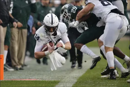  ?? THE ASSOCIATED PRESS FILE ?? Penn State quarterbac­k Sean Clifford, left, dives for a first down against Michigan State’s Shakur Brown.