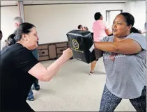  ?? [SARAH PHIPPS/ THE OKLAHOMAN] ?? Sandy Humphrey, left, and Yvette Deshazer practice throwing punches during a self-defense class for employees of the Office of Juvenile Affairs.