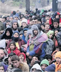  ??  ?? Crisis Refugees wait to pass through a police cordon before crossing the Greek-macedonian border near the village of Idomeni, Greece.