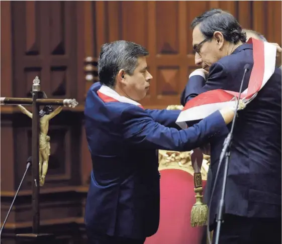  ??  ?? El titular del Congreso, Luis Galarreta, colocó la banda presidenci­al a Martín Vizcarra, quien sustituyó ayer a Pedro Pablo Kuczynski.