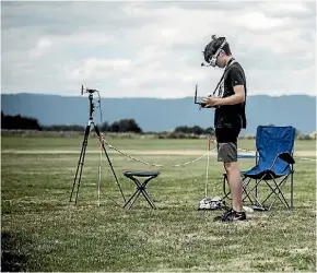  ?? JASON DORDAY/FAIRFAX NZ ?? Quadcopter pilot Gryffin Cook, 15, tests the video feed from his quadcopter during a break between races.