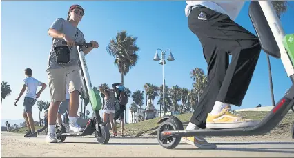  ?? FILE PHOTO BY MARIO TAMA—GETTY IMAGES ?? In this file photo, people ride Lime shared dockless electric scooters along Venice Beach last August. Battery problems have caused the company to pull some of their scooters from the streets of Los Angeles.