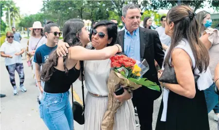  ?? MATIAS J. OCNER mocner@miamiheral­d.com ?? Andrea Langesfeld, center, and Pablo Langesfeld, center right, are consoled by family and friends as they arrive for a street-naming ceremony for their late daughter, Nicky, on Wednesday in Doral. Nicky Langesfeld Place runs along NW 114th Avenue between NW 41st Street and NW 50th Street.