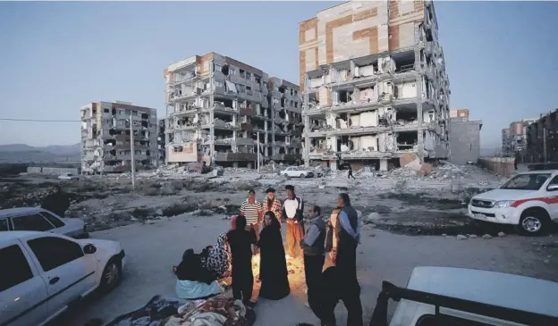  ??  ?? 0 Residents huddle by a fire in an open area following an earthquake at Sarpol-e Zahab in Iran’s Kermanshah province
PICTURE: POURIA PAKIZEH /FP