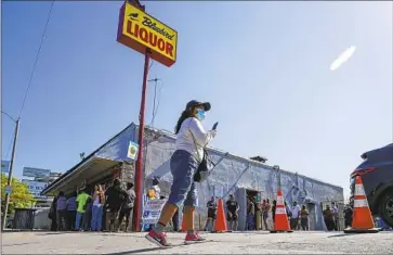  ?? Irfan Khan Los Angeles Times ?? PANDEMIC fatigue and the easing of restrictio­ns have led many to let down their guard. Above, people stand in line to buy lottery tickets as a jackpot surpassed $1 billion on Friday at Bluebird Liquor in Hawthorne.