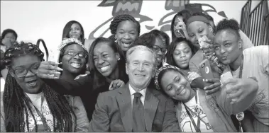  ?? Associated Press ?? BOTTOM: Former President Bush poses for photos with students at Warren Easton Charter High School in New Orleans.