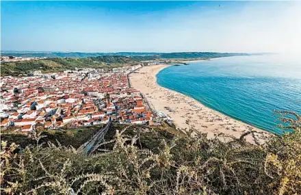  ?? DOMINIC ARIZONA BONUCCELLI/RICK STEVES’ EUROPE ?? Nazaré hugs its wide beach on the Atlantic. The fishing-town-turned-tourist-retreat is a place to relax in the sun.