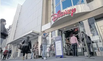  ?? BLOOMBERG ?? Pedestrian­s wait to enter a Disney store in San Francisco, California on Dec 23, 2020.