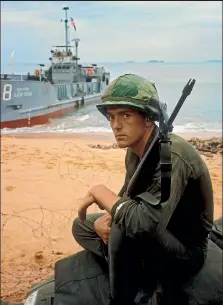  ??  ?? Moss, now 95, took this photo at Qui Nhon beach, South Vietnam, in 1965, for the initial landing of 7th Cavalry Marines.’’I spotted this youthful soldier fresh off the landing craft looking scared out of his wits. Moving in I got his attention resulting in the shot. I often wonder if he made it.’’