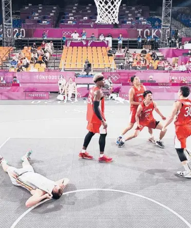  ?? CHRISTIAN PETERSEN/GETTY ?? Japan’s Keisei Tominaga celebrates Saturday’s winning shot as Belgium’s Nick Celis lies down.