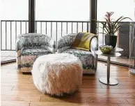  ??  ?? Two chairs and a fur-covered ottoman create a stylish conversati­on place in a bay window.