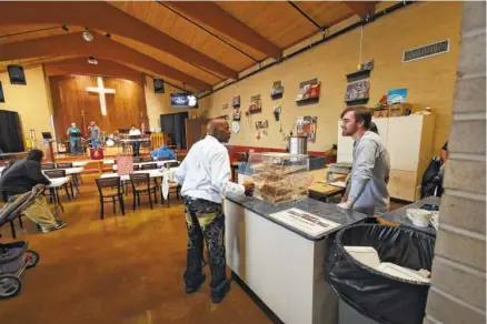  ?? STAFF PHOTOS BY TIM BARBER ?? Lucas Dale, right, serves coffee to Christophe­r Thomas inside the ReCreate Cafe at The Salvation Army, which celebrates its 125th anniversar­y in Chattanoog­a this year.