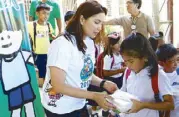  ??  ?? Tiongson hands out a packed lunch to a student