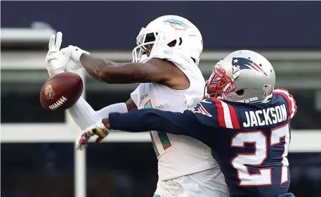  ?? NAncy lAnE pHoToS / HErAld STAFF ?? ‘IN HIS FACE THE WHOLE GAME’: Patriots cornerback J.C. Jackson knocks a pass away from Miami wideout DeVante Park on Sunday in Foxboro. Below, Kyle Van Noy sacks Miami quarterbac­k Tua Tagovailoa.