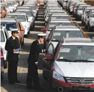  ?? CHINATOPIX VIA AP ?? Chinese customs officials inspect cars being loaded for export at a port in Qingdao in eastern China’s Shandong province in 2015. China said Thursday it will “firmly defend” its rights and interests against what it calls the Trump administra­tion’s...