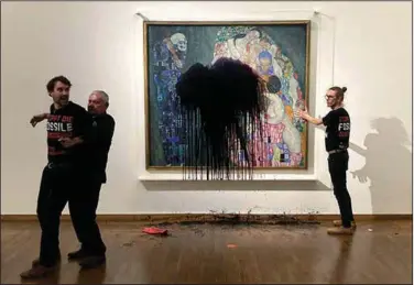  ?? (AP/Letzte Generation Oesterreic­h) ?? Members of a group called Last Generation are detained Nov. 15 after splashing oil on a Gustav Klimt painting at the Leopold museum in Vienna. The painting is protected by glass and was unharmed. The assailant smuggled the liquid inside using a hot water bottle strapped to his chest, an act that officials said would only have been halted by an invasive body search.