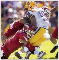  ?? NWA Democrat-Gazette/BEN GOFF ?? The Razorbacks’ Santos Ramirez (left) and Kevin Richardson tackle LSU’s Derrick Dillon in the second quarter Saturday at Tiger Stadium in Baton Rouge.