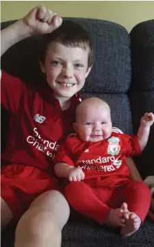  ??  ?? Liverpool-mad fans James Whelan, aged 9, with his 16-week-old sister, Ellie, in Killarney.