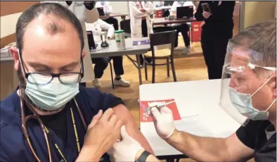  ?? Contribute­d photo ?? Dr. Guillermo Ballarino, pulmonary intensivis­t, gets the first COVID-19 vaccine at Danbury Hospital.