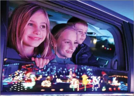  ?? PHOTOS BY PETE BANNAN — DIGITAL FIRST MEDIA ?? Sarah, Annabelle and Tommy Speers check out Jerry and Jean Corrado’s Christmas light display on Nobb Hill Drive. The couple uses the display to collect toys to be donated to children admitted to the emergency room and pediatrics unit at Chester County...