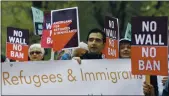  ?? TED S. WARREN — THE ASSOCIATED PRESS FILE ?? On May 15, 2017, protesters hold signs during a demonstrat­ion against President Donald Trump’s revised travel ban while demonstrat­ing outside a federal courthouse in Seattle.