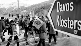  ?? AP ?? Hundreds of climate protesters who are on a three-day protest march from Landquart to Davos pass the city of Klosters, Switzerlan­d, on Monday. The World Economic Forum starts today, Tuesday.