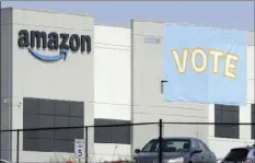  ?? AP PHOTO/JAY REEVES ?? In this March 30 file photo, a banner encouragin­g workers to vote in labor balloting is shown at an Amazon warehouse in Bessemer, Ala. Amazon workers voted against forming a union, Friday in Alabama, handing the online retail giant a decisive victory and cutting off a path that labor activists had hoped would lead to similar efforts throughout the company and beyond.