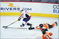  ??  ?? Matt Slocum - The Associated Press
Flyers defenseman Travis Sanheim dives to try to knock the puck away from Washington Capitals forward T.J. Oshie, left, while Flyers center Sean Couturier looks on during the third period Sunday night at Wells Fargo Center.