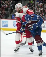  ?? DAVID ZALUBOWSKI — THE ASSOCIATED PRESS ?? Detroit Red Wings’ Jordan Oesterle, back, clears out Colorado Avalanche’s J.T. Compher from near the net during Detroit’s 6-3loss on Monday. Colorado scored the game’s first five goals.