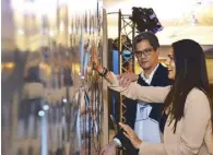  ??  ?? Erwin Romulo and Iza Calzado try the sound art installati­on called All Watched Over by
Machines by WSK sound art collective.