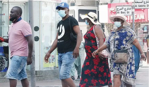  ?? John Varughese/gulf Today ?? ↑
Residents stroll along an avenue during an outing.